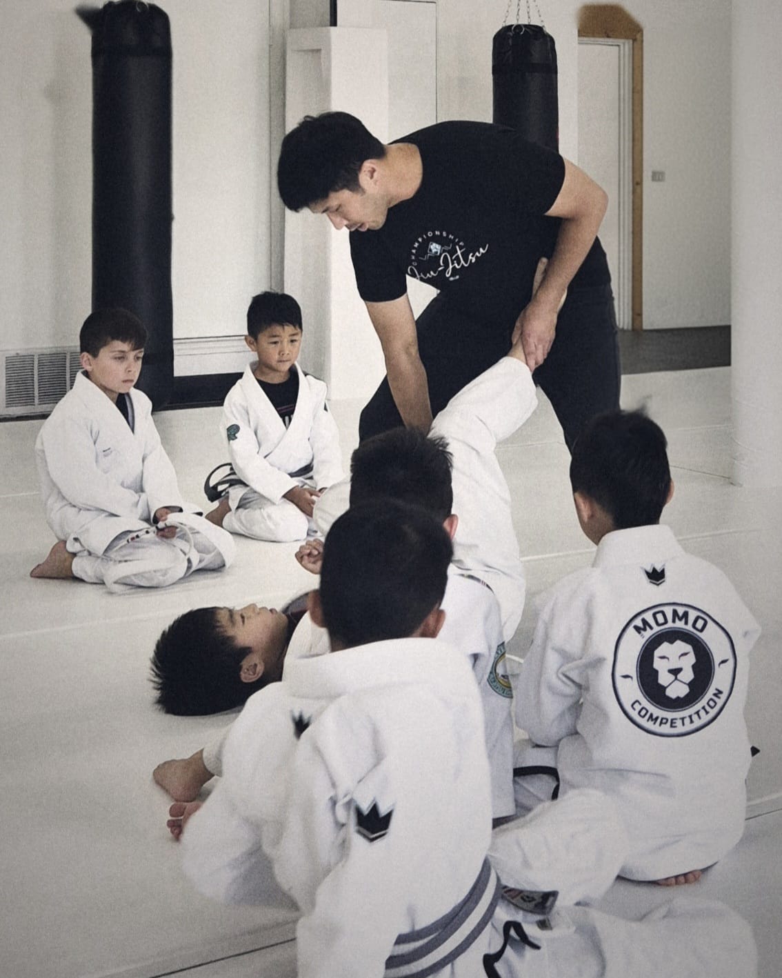 Brian coaching youth BJJ students on the mat