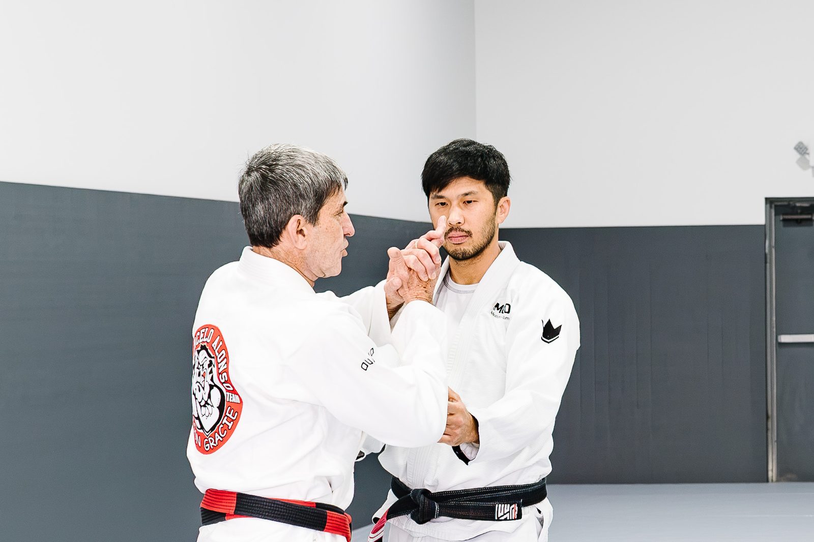 Coral belt Marcelo Alonso working through a technique with Coach Brian Yi at MOMO BJJ